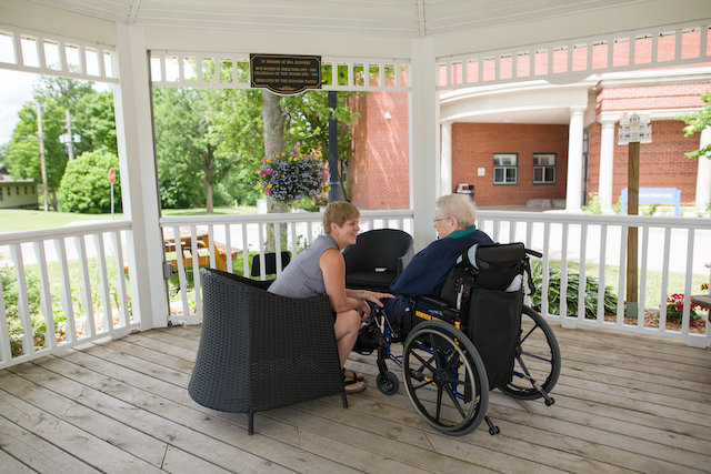 Patient in wheelchair in the gazebo with RVH staff person